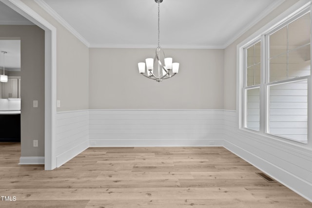 unfurnished dining area featuring hardwood / wood-style floors, a chandelier, and ornamental molding