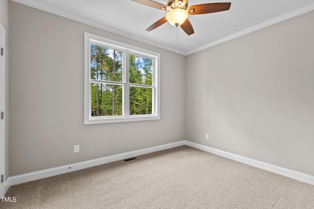 empty room featuring ceiling fan, ornamental molding, and carpet flooring