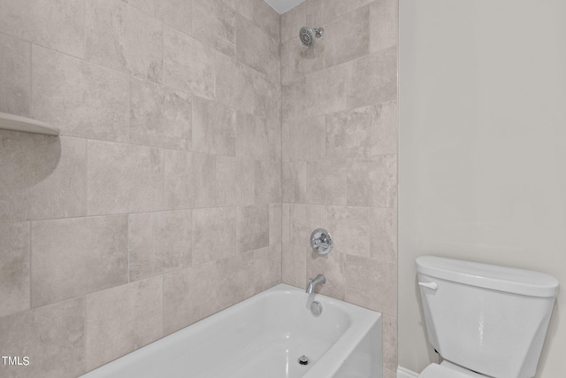 bathroom featuring tiled shower / bath combo and toilet