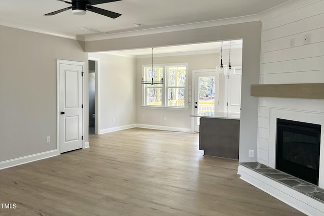 unfurnished living room featuring crown molding, ceiling fan, hardwood / wood-style floors, and a tile fireplace