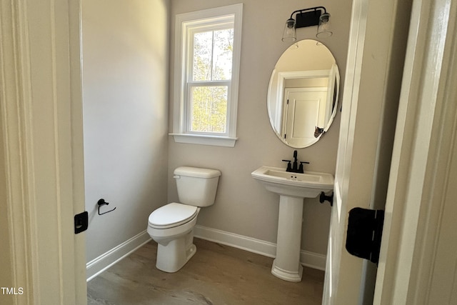 bathroom featuring wood-type flooring, sink, and toilet