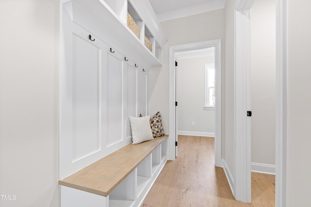 mudroom with ornamental molding, light wood finished floors, and baseboards