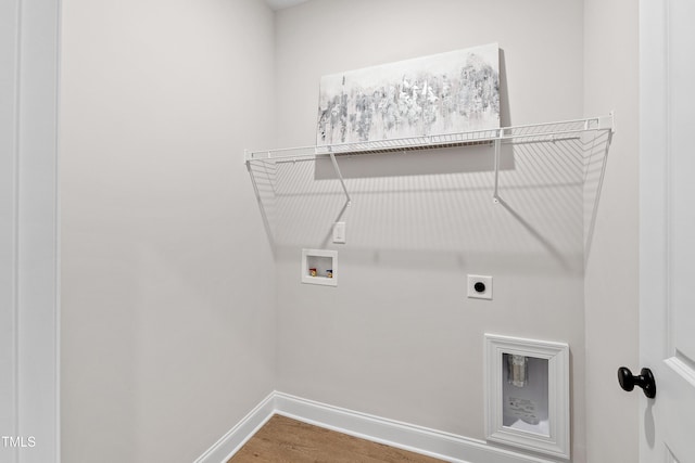 clothes washing area featuring hookup for an electric dryer, laundry area, washer hookup, wood finished floors, and baseboards