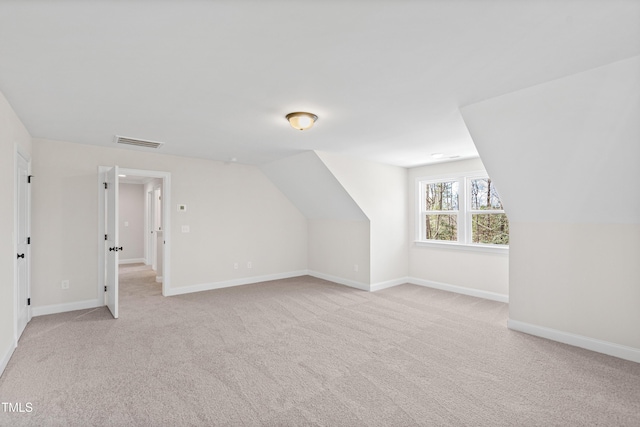 bonus room featuring baseboards, lofted ceiling, visible vents, and light colored carpet