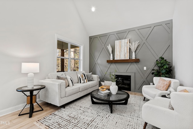 living room featuring high vaulted ceiling and light hardwood / wood-style flooring