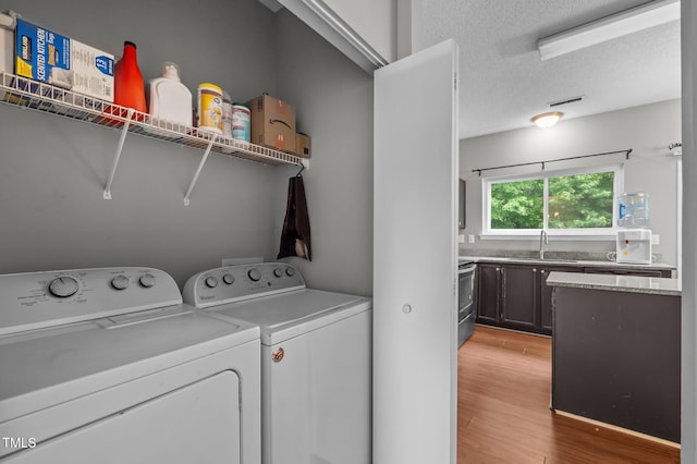 612 Quartz Dr, Durham, NC 27703 - washroom with washer and clothes dryer, light wood-style flooring, and a textured ceiling