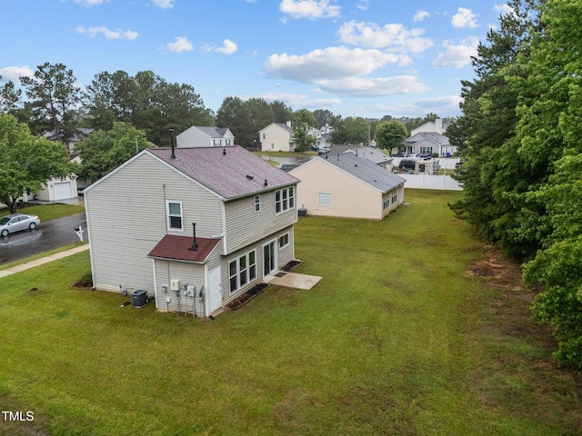 612 Quartz Dr, Durham, NC 27703 - back of house with roof with shingles, a lawn, a residential view, and central air condition unit