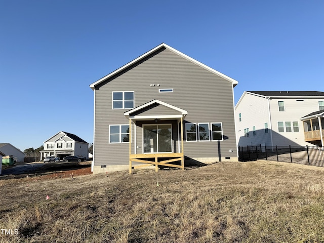 back of house featuring crawl space, a sunroom, and fence