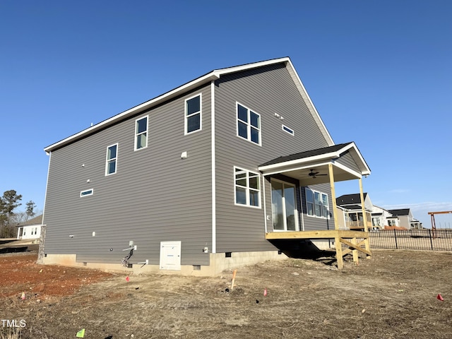 rear view of house with crawl space, a ceiling fan, and fence