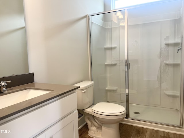full bathroom with wood finished floors, vanity, toilet, and a stall shower