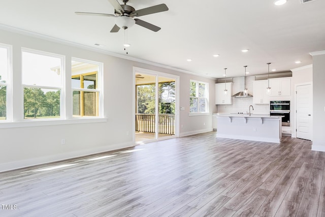592 Barbour Farm Ln, Four Oaks, NC 27524 - unfurnished living room with ornamental molding, light wood finished floors, a ceiling fan, and recessed lighting
