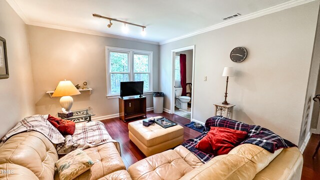 living area with track lighting, wood finished floors, ornamental molding, and baseboards