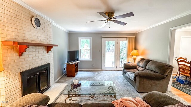 living area featuring a ceiling fan, a fireplace, light colored carpet, baseboards, and crown molding