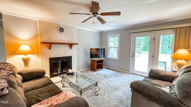 carpeted living area featuring a ceiling fan, crown molding, baseboards, and a fireplace