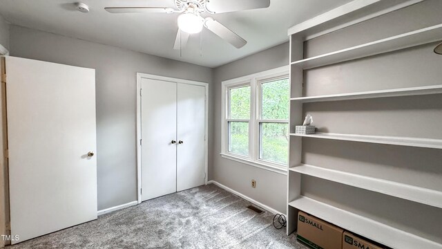 unfurnished bedroom with carpet floors, baseboards, ceiling fan, and a closet