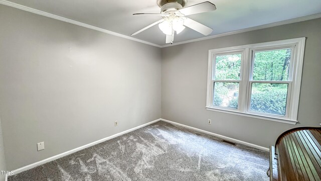 spare room with carpet, baseboards, a ceiling fan, and ornamental molding
