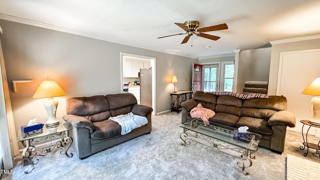 living area with carpet flooring, ornamental molding, ceiling fan, and baseboards