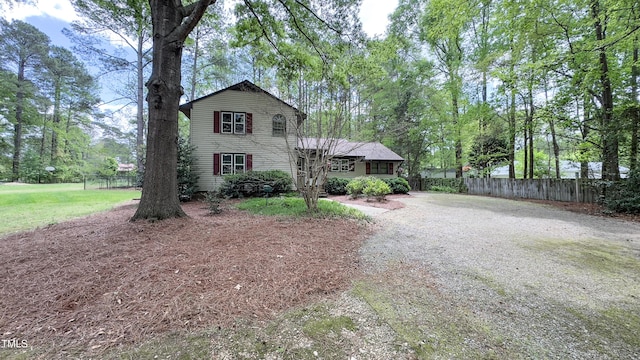 view of front of house with dirt driveway and fence