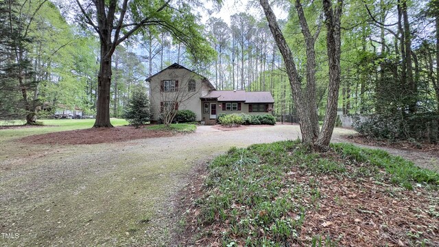 split level home with dirt driveway