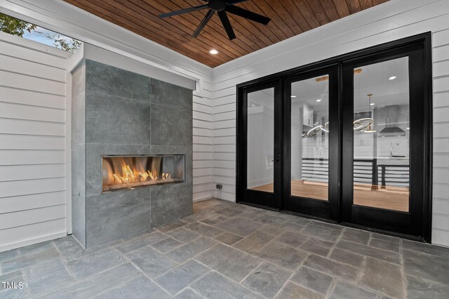 view of patio / terrace with a tiled fireplace, ceiling fan, and french doors