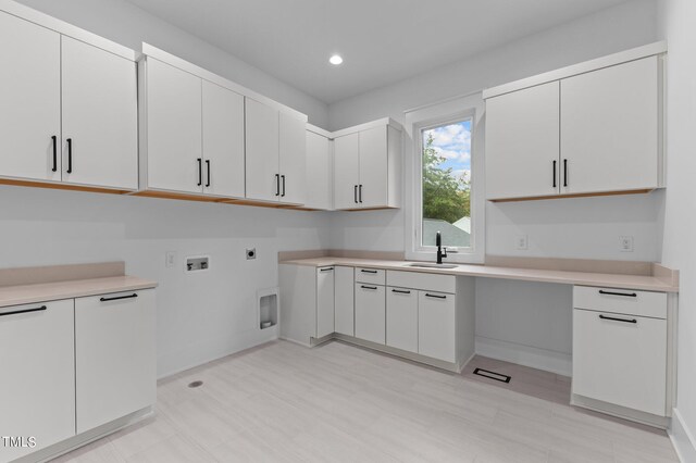 laundry area featuring electric dryer hookup, cabinets, sink, and washer hookup