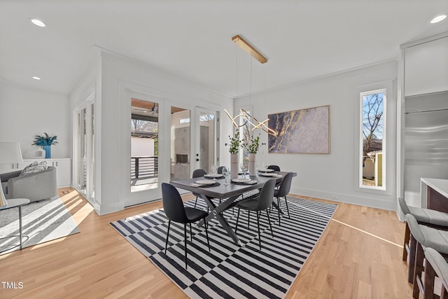 dining space featuring light hardwood / wood-style flooring, a healthy amount of sunlight, and ornamental molding