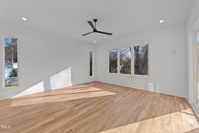 unfurnished room featuring light hardwood / wood-style floors, plenty of natural light, ceiling fan, and ornamental molding