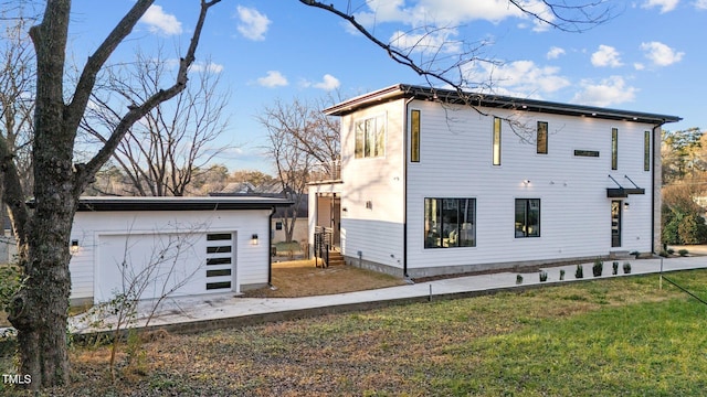 rear view of house with a lawn and a garage