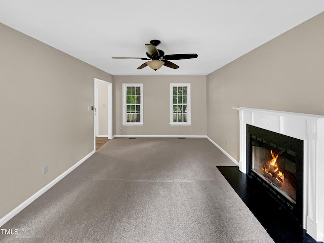 unfurnished living room with dark colored carpet and ceiling fan