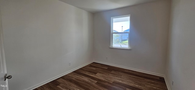 unfurnished room with dark hardwood / wood-style flooring