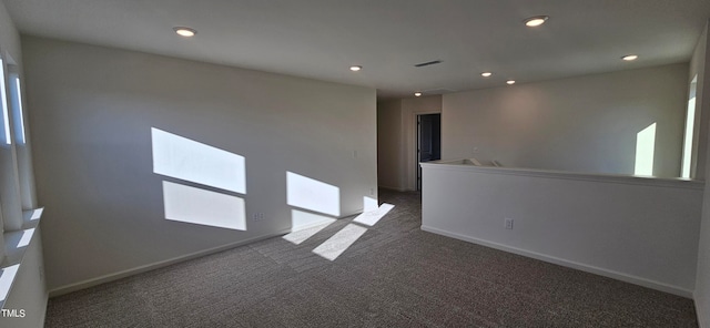 unfurnished room featuring dark carpet