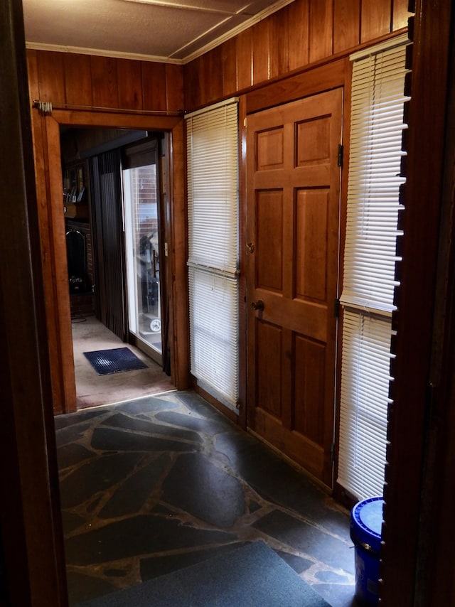 entryway featuring ornamental molding and wooden walls