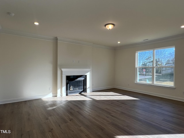 unfurnished living room featuring crown molding and dark wood-type flooring