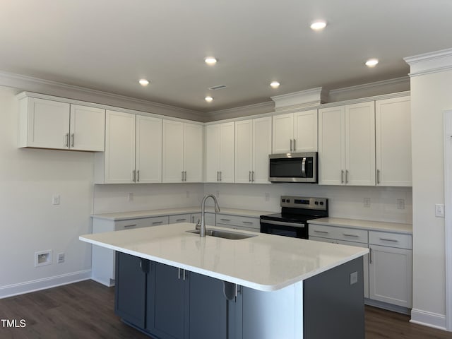 kitchen with appliances with stainless steel finishes, a center island with sink, white cabinetry, and sink