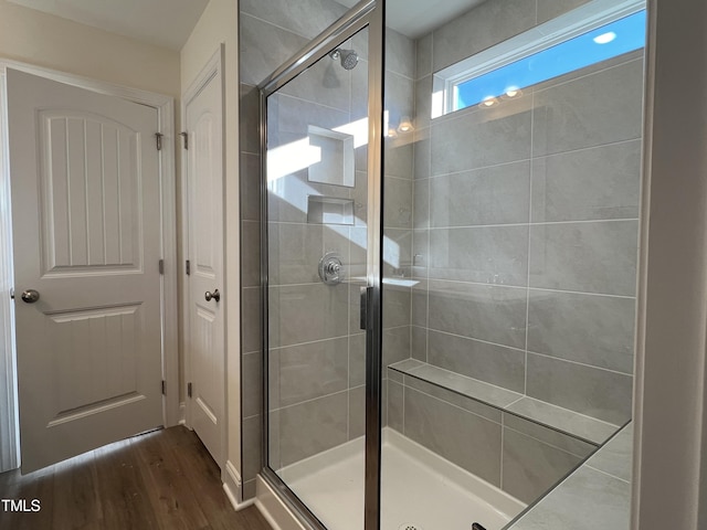 bathroom featuring hardwood / wood-style floors and a shower with door