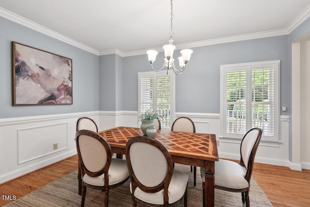 7811 Still Crossing Rd, Chapel Hill, NC 27516 - dining room with a chandelier, light wood finished floors, crown molding, healthy amount of natural light, and a wainscoted wall