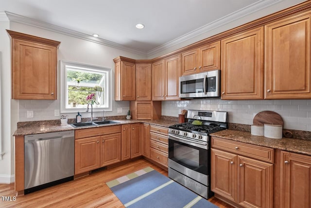 7811 Still Crossing Rd, Chapel Hill, NC 27516 - kitchen featuring appliances with stainless steel finishes, a sink, light wood-type flooring, crown molding, and decorative backsplash