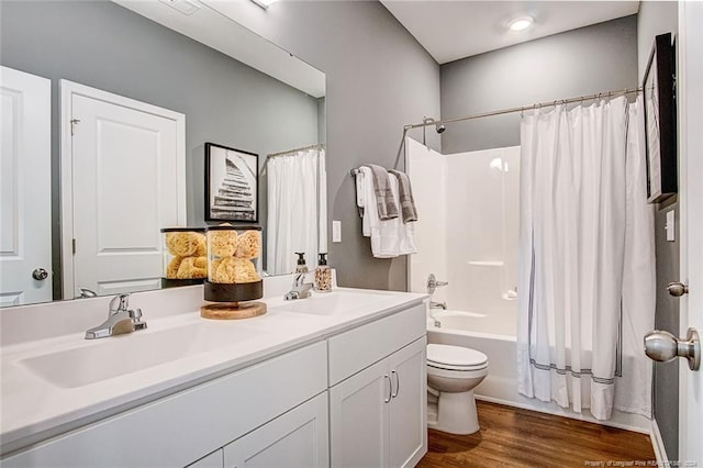 full bathroom featuring toilet, hardwood / wood-style floors, vanity, and shower / tub combo with curtain