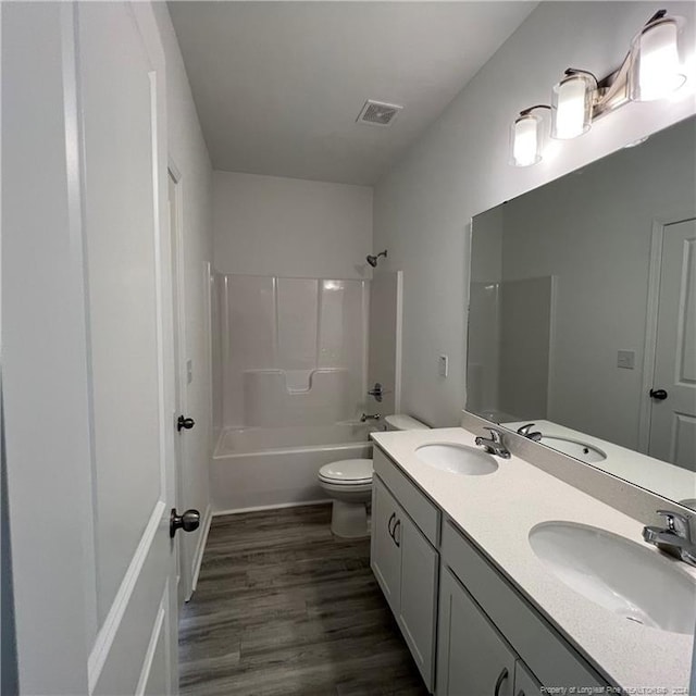 full bathroom featuring vanity, toilet, wood-type flooring, and bathtub / shower combination