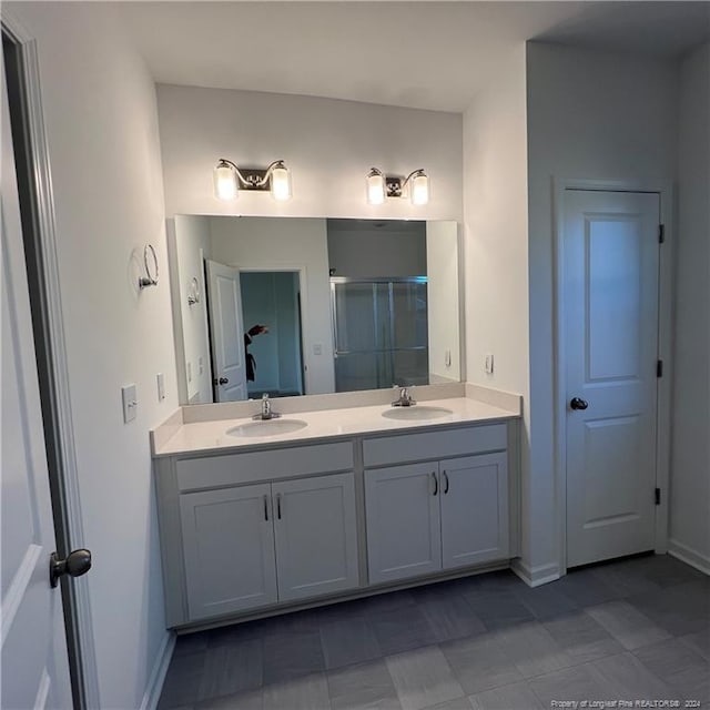 bathroom with vanity and a shower with door