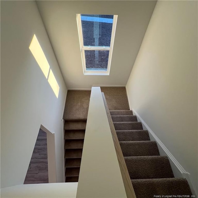 staircase with carpet and a towering ceiling