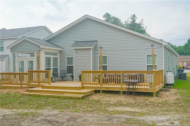 rear view of property featuring central AC and a wooden deck