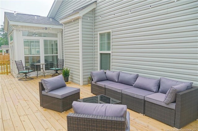 wooden deck featuring an outdoor living space and a sunroom