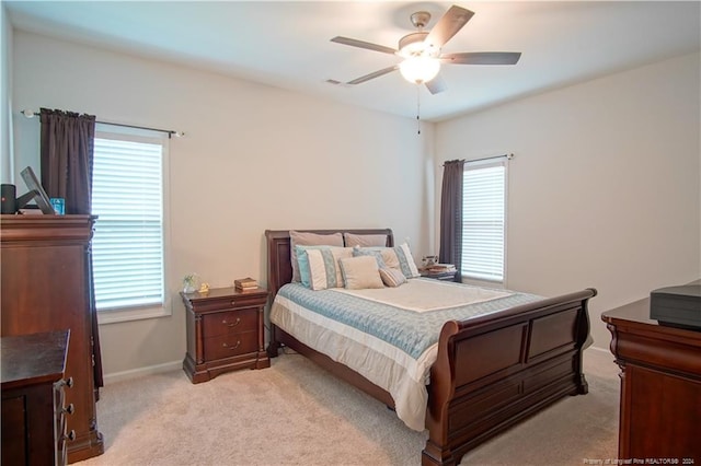 bedroom with light carpet, baseboards, and a ceiling fan