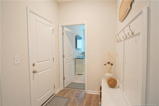 mudroom featuring wood finished floors and baseboards