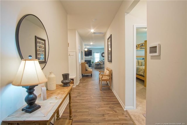 hallway featuring wood finished floors and baseboards