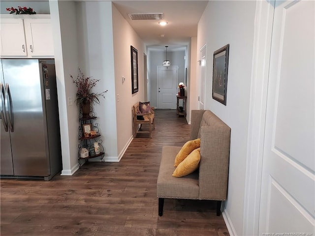 hall with dark wood-style flooring and baseboards