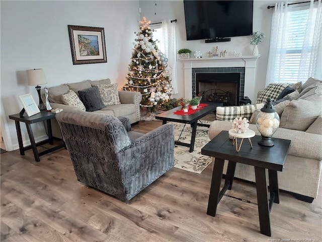 living room with light wood-type flooring and a tile fireplace