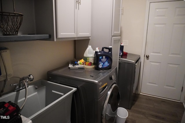 clothes washing area with cabinets, separate washer and dryer, dark hardwood / wood-style floors, and sink