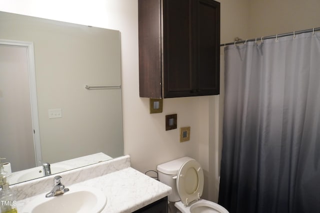 bathroom featuring toilet, vanity, and curtained shower